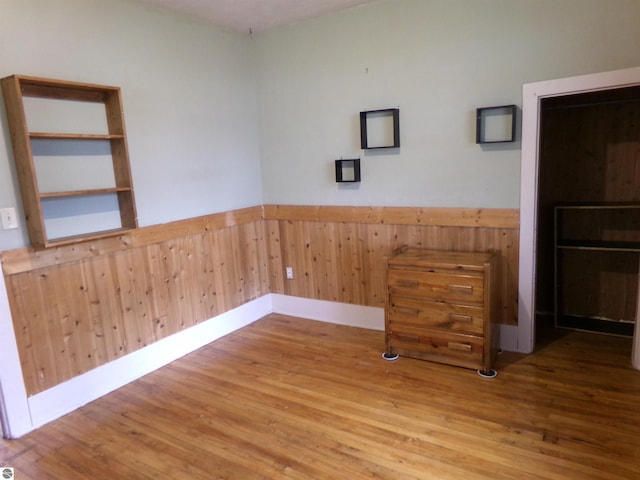 116 N Main St, Saint Louis, MI 48880 - spare room featuring wood finished floors, wood walls, and wainscoting