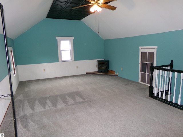 116 N Main St, Saint Louis, MI 48880 - additional living space with a wood stove, vaulted ceiling, carpet, and ceiling fan