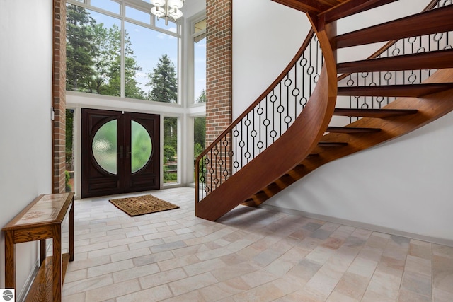 5343 Michibay Dr, Manistique, MI 49854 - foyer entrance with a notable chandelier, stairs, and a healthy amount of sunlight