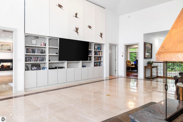 5343 Michibay Dr, Manistique, MI 49854 - living room featuring marble finish floor, a towering ceiling, baseboards, and built in features