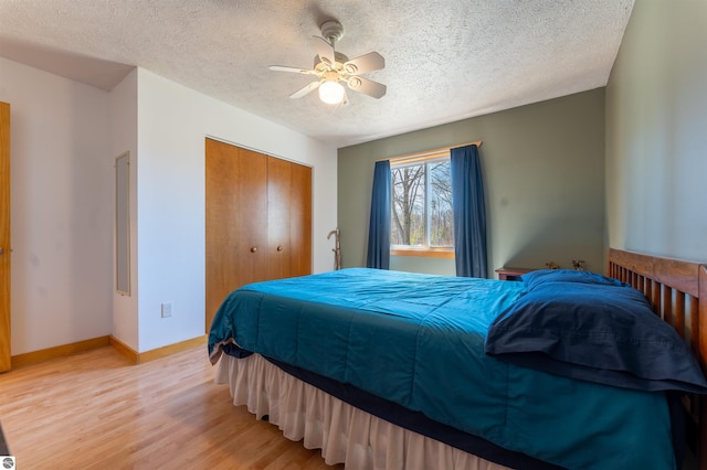1294 Fisher Rd, Traverse City, MI 49685 - bedroom featuring a ceiling fan, light wood-style floors, a closet, baseboards, and a textured ceiling
