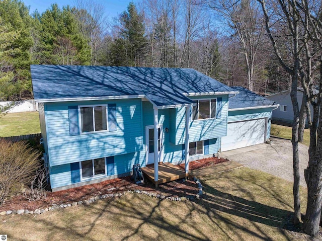 1294 Fisher Rd, Traverse City, MI 49685 - split foyer home featuring a garage, roof with shingles, and a front lawn