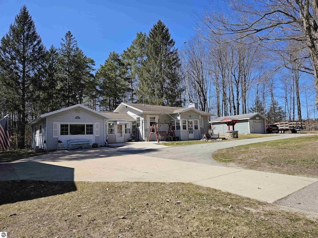 7497 N 7 Mile Rd, Lake City, MI 49651 - ranch-style house with a porch, driveway, an outdoor structure, and a chimney