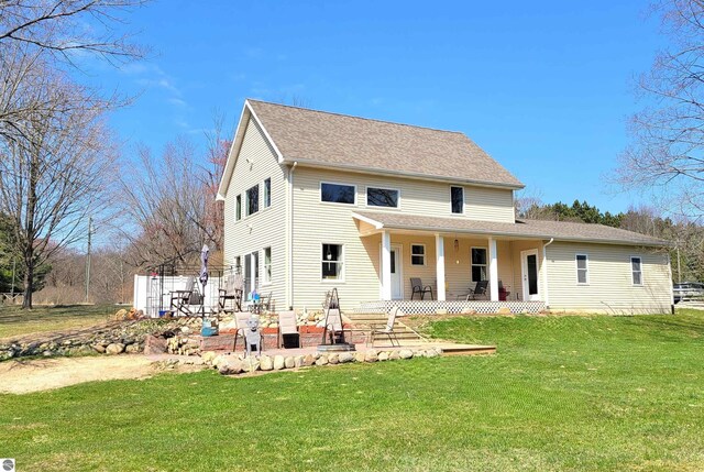 734 N Rolland Rd, Lake Isabella, MI 48893 - rear view of property with a lawn, a patio, and roof with shingles
