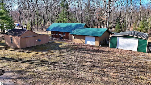 8991 W Oak Ln, Lake City, MI 49651 - view of front of property featuring a garage, metal roof, and an outdoor structure