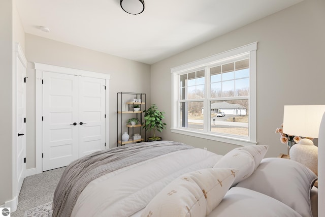 bedroom with baseboards, carpet flooring, and a closet
