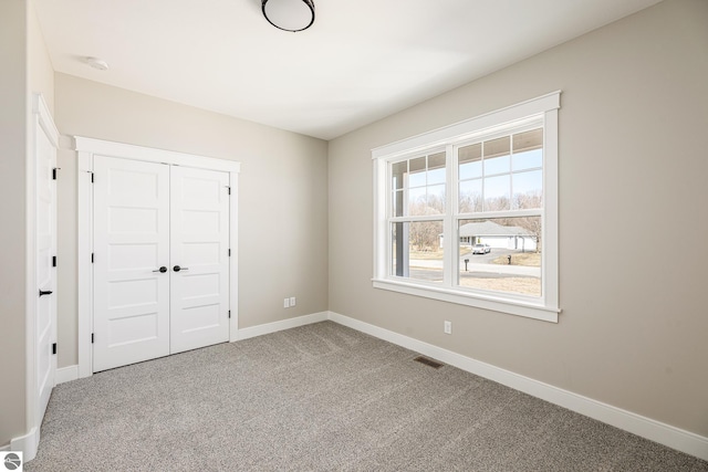unfurnished bedroom featuring carpet floors, a closet, and baseboards