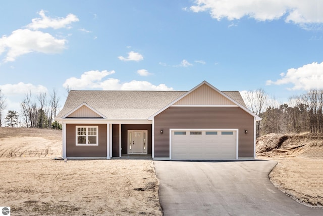 view of front of property featuring aphalt driveway, covered porch, a shingled roof, and a garage