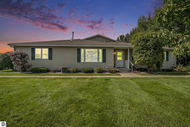 single story home featuring a yard and central AC unit