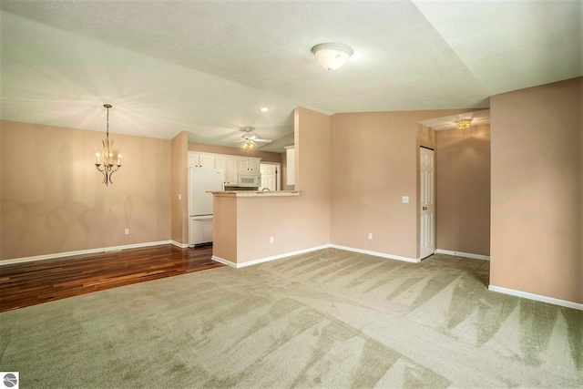 unfurnished living room with vaulted ceiling, baseboards, carpet, and a ceiling fan