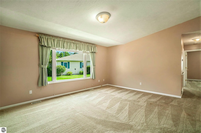 carpeted spare room featuring visible vents and baseboards