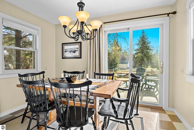 dining area with a chandelier and baseboards
