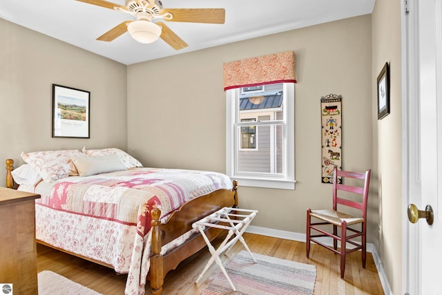 bedroom featuring wood finished floors, a ceiling fan, and baseboards