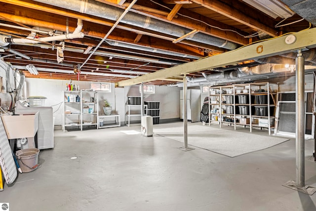below grade area featuring washer / clothes dryer, a sink, and freestanding refrigerator