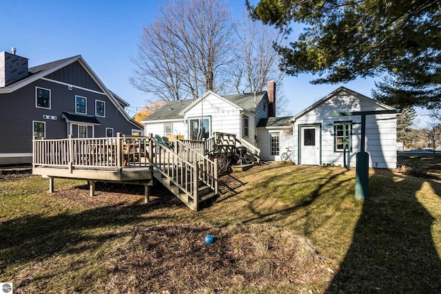 rear view of property featuring a wooden deck, a chimney, and a yard