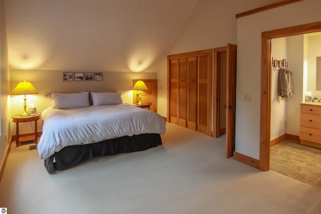 bedroom featuring lofted ceiling, baseboards, and light colored carpet