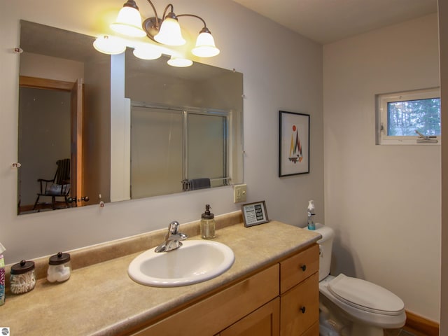 full bath featuring a chandelier, a shower stall, toilet, and vanity