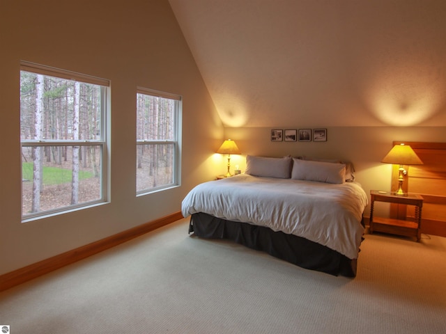 bedroom featuring lofted ceiling, baseboards, carpet floors, and multiple windows