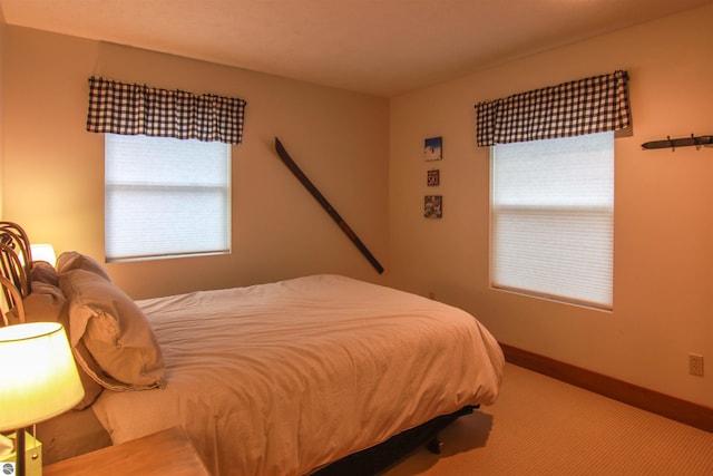 bedroom with baseboards and carpet