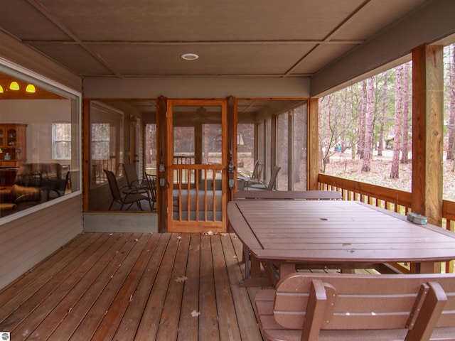 wooden terrace with a sunroom and outdoor dining space