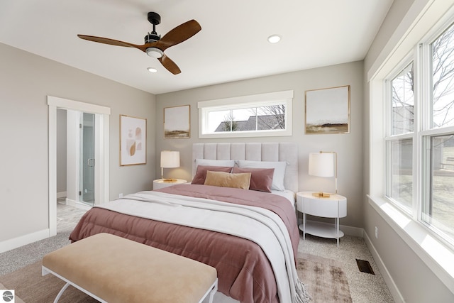 bedroom with baseboards, visible vents, light colored carpet, and multiple windows