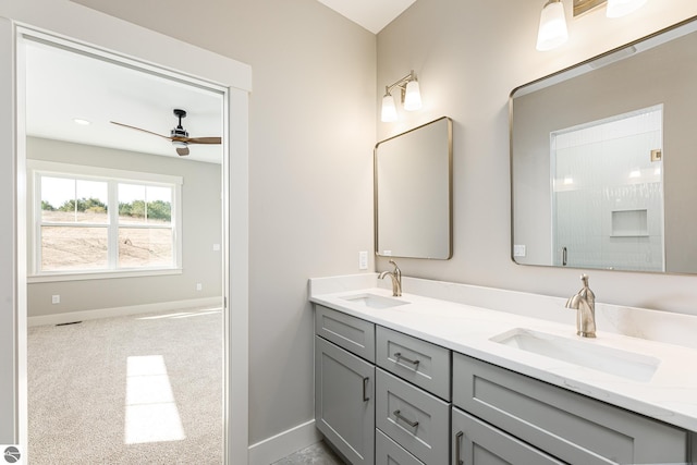 full bathroom featuring double vanity, a ceiling fan, baseboards, and a sink