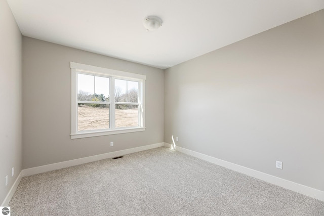 carpeted spare room with baseboards and visible vents