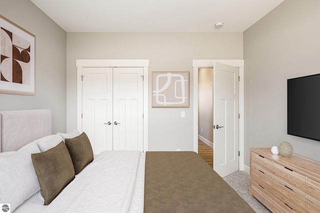 bedroom with baseboards, carpet flooring, and a closet