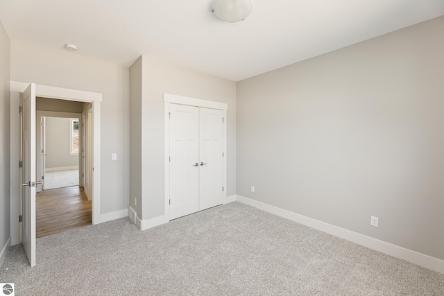 unfurnished bedroom with carpet floors, a closet, and baseboards