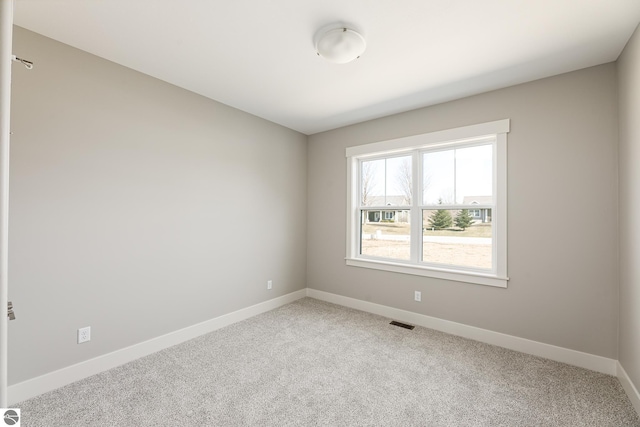 empty room with visible vents, baseboards, and light carpet