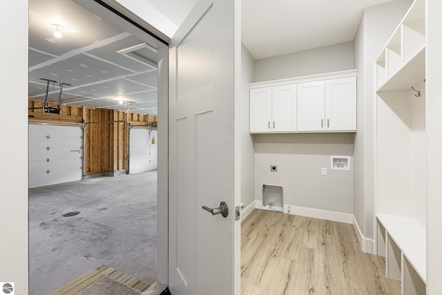 laundry area featuring hookup for an electric dryer, baseboards, a garage, cabinet space, and washer hookup