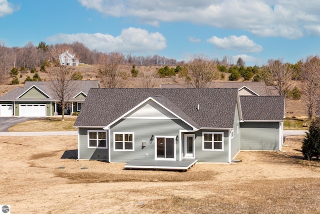 ranch-style house with roof with shingles and a deck