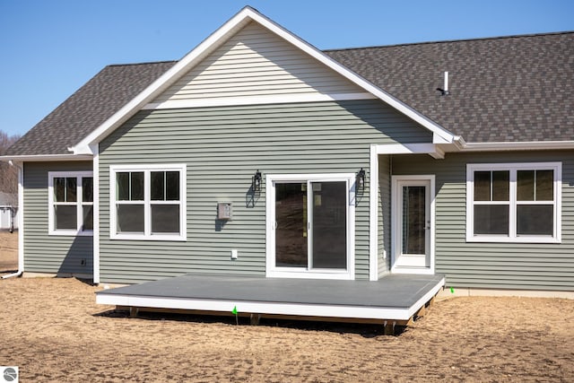 back of property featuring a wooden deck and roof with shingles