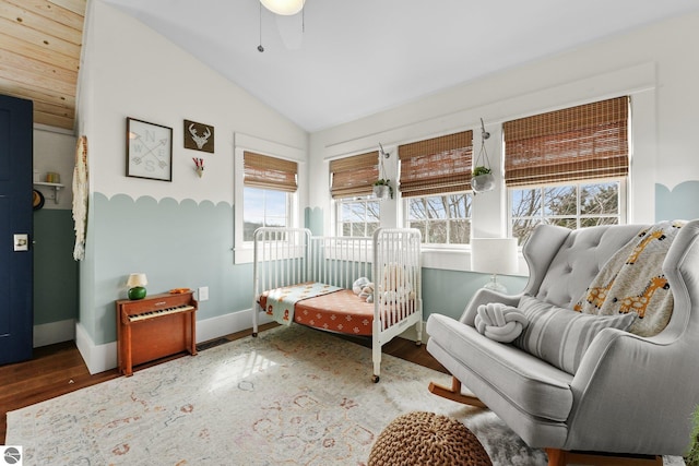 interior space with vaulted ceiling, wood finished floors, baseboards, and ceiling fan