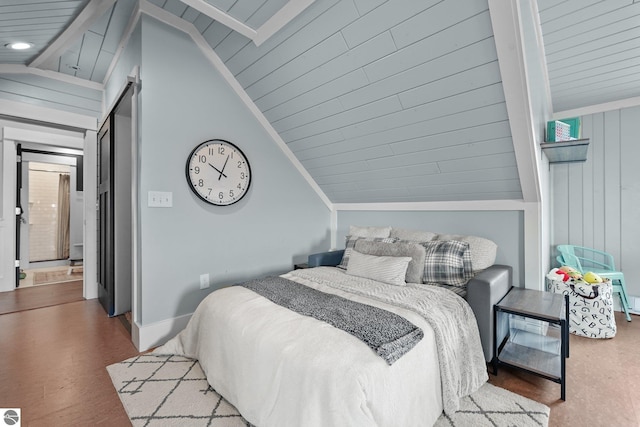 bedroom featuring lofted ceiling, baseboards, and wood finished floors