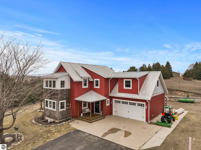 view of front of home with an attached garage, aphalt driveway, and metal roof