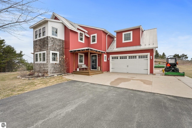 view of front of house with a garage, metal roof, and aphalt driveway