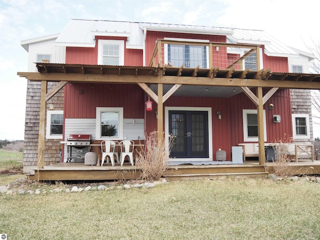 back of house featuring a lawn, a deck, and french doors