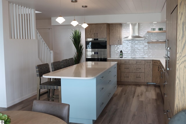 745 S Crescent Ave, Au Gres, MI 48703 - kitchen featuring stainless steel double oven, black electric stovetop, a kitchen breakfast bar, wall chimney exhaust hood, and wood finished floors