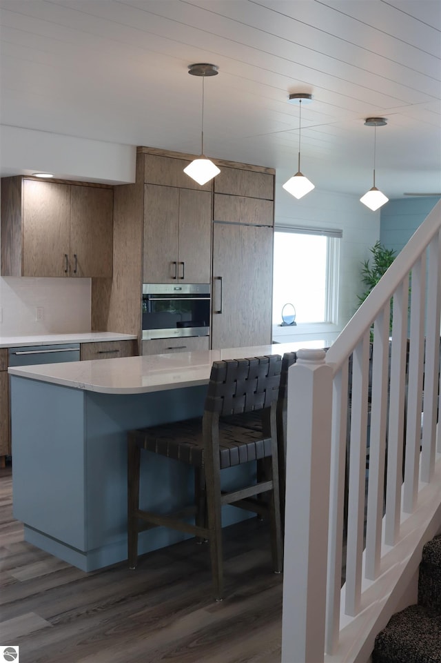 745 S Crescent Ave, Au Gres, MI 48703 - kitchen with light countertops, oven, decorative light fixtures, and dark wood-type flooring