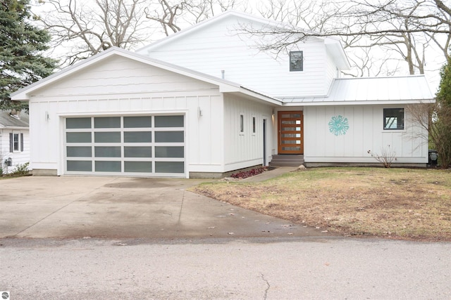 745 S Crescent Ave, Au Gres, MI 48703 - view of front facade with a garage, board and batten siding, driveway, and metal roof