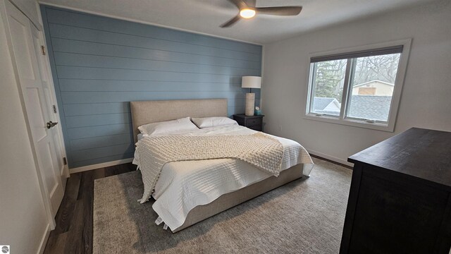 745 S Crescent Ave, Au Gres, MI 48703 - bedroom with wooden walls, baseboards, ceiling fan, and wood finished floors