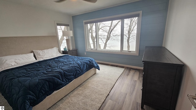 745 S Crescent Ave, Au Gres, MI 48703 - bedroom with wood walls, a ceiling fan, and wood finished floors