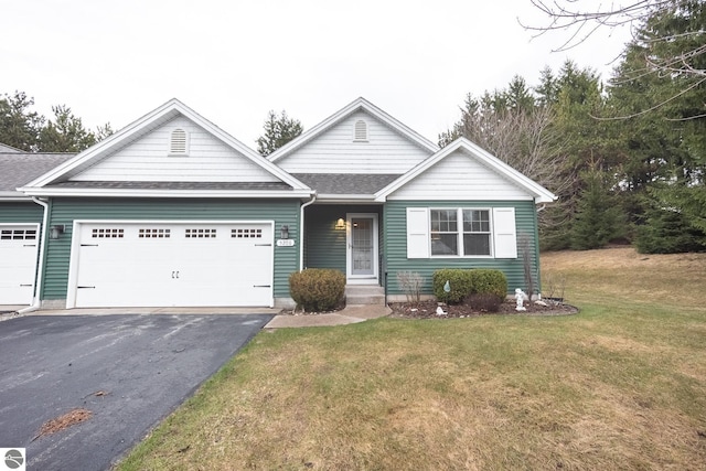 view of front of house featuring an attached garage, driveway, a shingled roof, and a front yard