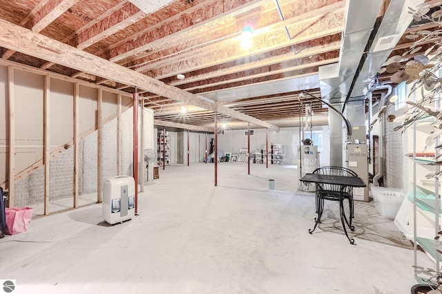 unfinished below grade area featuring water heater and heating unit