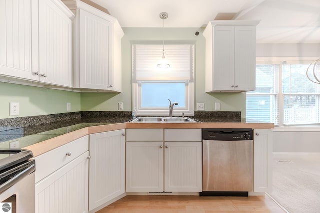 kitchen featuring a sink, visible vents, white cabinetry, appliances with stainless steel finishes, and hanging light fixtures