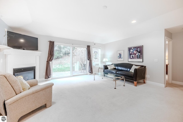 living area with a glass covered fireplace, carpet floors, and baseboards