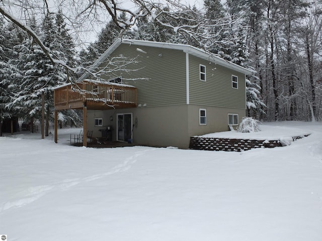 view of snow covered exterior with a wooden deck