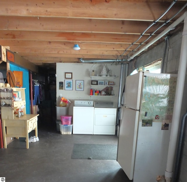 basement featuring separate washer and dryer and freestanding refrigerator