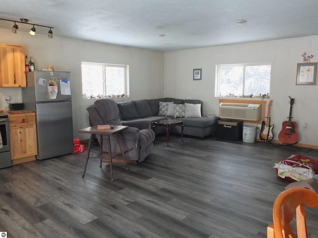 living area featuring a wall mounted AC, dark wood-style floors, and a wealth of natural light
